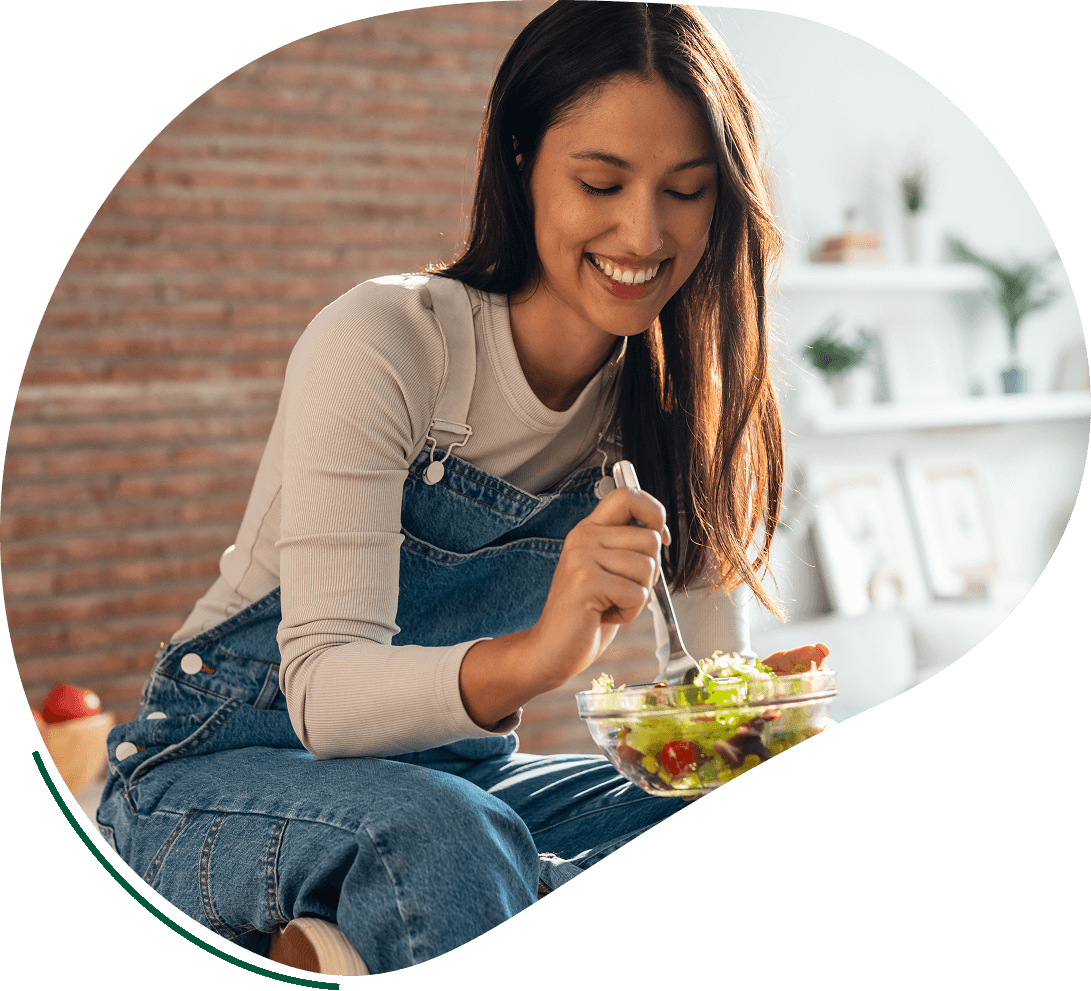 A woman sitting on the ground eating food.