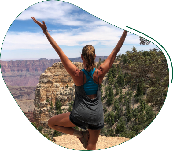 A woman is doing yoga on top of a mountain