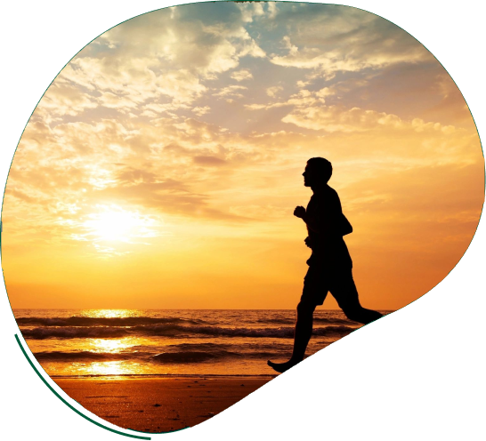 A person running on the beach at sunset